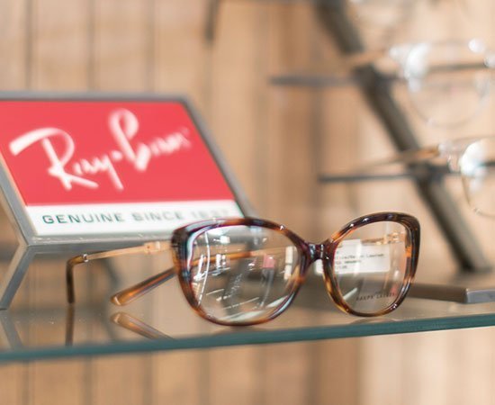ray ban glasses in front of branded sign